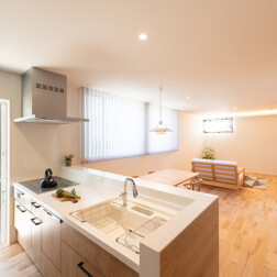 キッチンからLDK全部を見渡すことが出来ます。自然な光が差し込み、明るく温かみがあります。床は無垢床(バーチ材)を採用。リビングの窓は、外からの視線を考え腰壁仕様にしました。