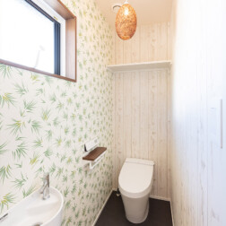 2階トイレ(LIXIL サティス採用)。1階のトイレとイメージを変えて、ナチュラルに。それに合わせて照明も選びました。