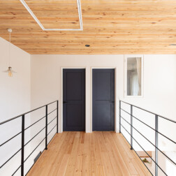 2階の廊下。空間をネイビーブルーの建具(LIXIL ラシッサD)が引き締めています。