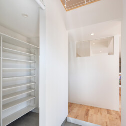 玄関は吹抜けにしたので、明るい玄関になりました。壁をつくり来客の時にはロールスクリーンで目隠しになるようにしています。