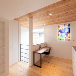 2Fのホール部分は家族のプライベート空間です。カウンタースペースをつくり、ホールの両側に壁面収納を設置。本はもちろん、小物や写真などを飾ったりと、活用できます。また、北欧のデザイン「マリメッコ」のカーテンが空間のアクセントになります。2Fの床材は赤松を使用。肌触りがやわらかい床が心地がよいです。