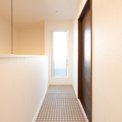 2階の廊下にグレーチングを採用。ベランダにつながる扉から入る光が、グレーチングを通し、1階のリビングに差し込みます。