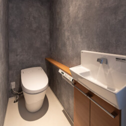 2階トイレ。壁全面をトキワのコンクリート調のクロスを貼り、かっこいいトイレ空間をつくりました。