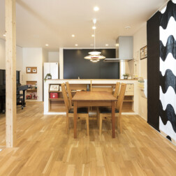 無垢床と照明やカーテン、キッチン収納建具などのインテリアとのコントラストが美しいLDK