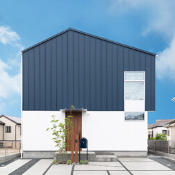 外観。ネイビーのガルバリウムとホワイトのサイディングの貼り分け。道行く人の視線を集める洗練されたお家が完成しました。