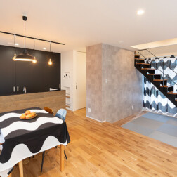 LDK - オーク材の床と黒で揃えた建具や照明、アイアン階段でヴィンテージ感のあるかっこいいイメージに。キッチンのカウンター面もヴィンテージオークで統一しました。 一段下がった畳スペースはお子様のお昼寝スペースに最適。また、玄関土間の黒板でお子様が遊んでいても開放的な空間だから家事をしながら見守る事ができます。