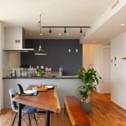 ダイニングスペース。キッチン背面のクロスをグレイッシュなネイビーカラーにし、空間をかっこよく引き締めています。