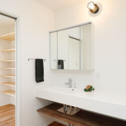 洗面スペースを独立させた間取りプラン。お2人のライフスタイルに適した生活動線と、来客時の動線など踏まえ設置。洗面室の奥には生活用品を収納できる大容量のパントリーをつくりました。