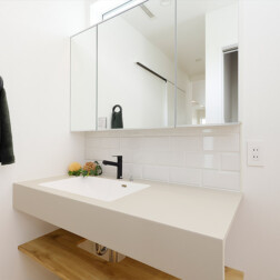 アイカのスタイリッシュカウンターを採用。廊下に設置されている洗面台はすっきりとおしゃれに。タイルが上品に、そして、タオル掛けは洗面コーナーのアクセントとなりました。