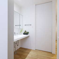 玄関扉をあけ左側の扉をあけると洗面スペースにつながります。ここからキッチンへつながり、買い物帰りの「ただいま動線」。洗面台はアイカのスタイリッシュカウンターを採用。