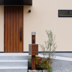 <玄関ポーチ>玄関ドアはLIXILのジエスタ2 D11型 チーク浮造り調を採用。天然木のあたたかみをリアルに再現された重厚感のある玄関扉がお家の顔となります。
スロープも取付け、玄関土間への荷物や自転車などの出入りに活用します。