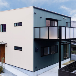 外観は四角いフォルムが印象的。正面のアクセントは無塗装のジョリパット(アイカT2022)。ベースには、ネオスパン ミストグリーン(ニチハ)を採用。正面の温かみのある色味と深みのあるグリーンのコントラストにより、個性的で印象的な外観となりました。