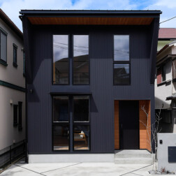 外壁にはブラックの立平のガルバリウム鋼板を採用。
軒天や玄関まわりに木目柄を取り入れ、シンプルでスタイリッシュながらも温かみのある外観に仕上げました。